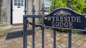 A sign for Wyreside Lodge with a traditional stone building in the background. - The Lodge House (Lancaster)