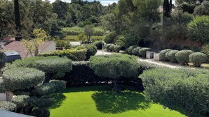 A well-maintained garden with various shrubs and a central lawn area. - VILLA M, Swimming pool, Beach on foot (La Croix-Valmer)
