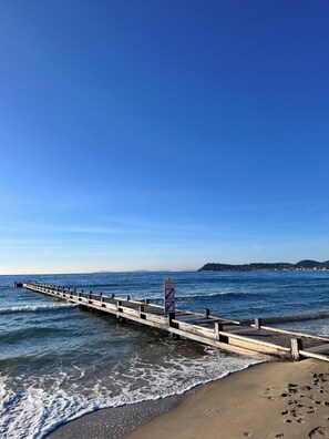 En mole der strækker sig ud i havet, med et skilt der viser, at badning ikke er tilladt.