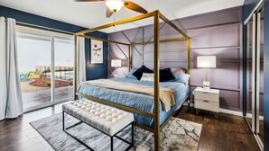 Un dormitorio con cama con dosel, ventilador de techo, banco y vistas al exterior.