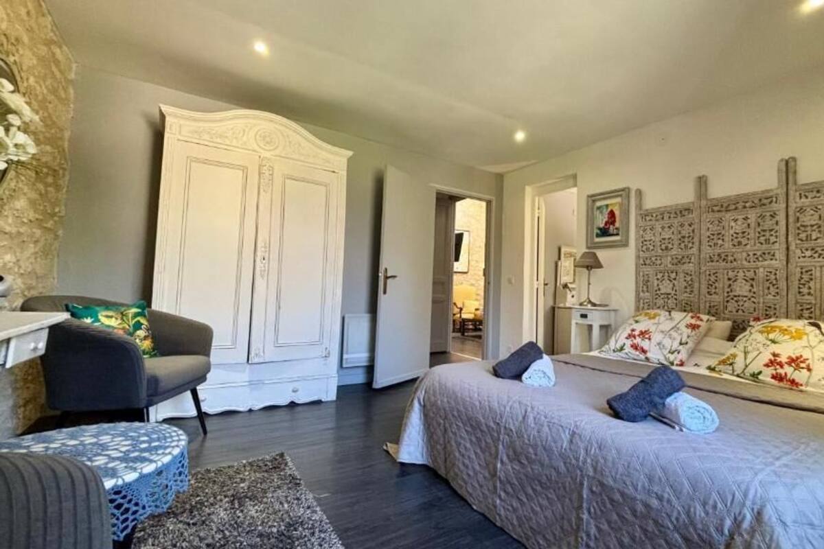 A bedroom with a bed, a chair, a wardrobe, and a desk.