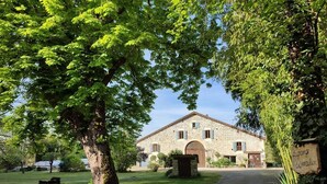 Un edificio de piedra con camino de grava y un letrero que dice "La Borde du Moulin".