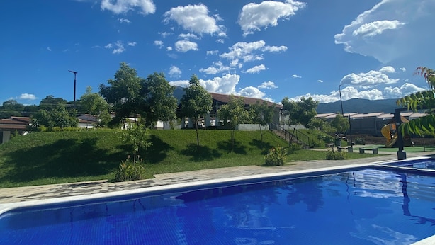 Une piscine, avec un ciel bleu clair et quelques nuages épars en arrière-plan.