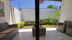 Un patio con sofá, sillas y una mesita.