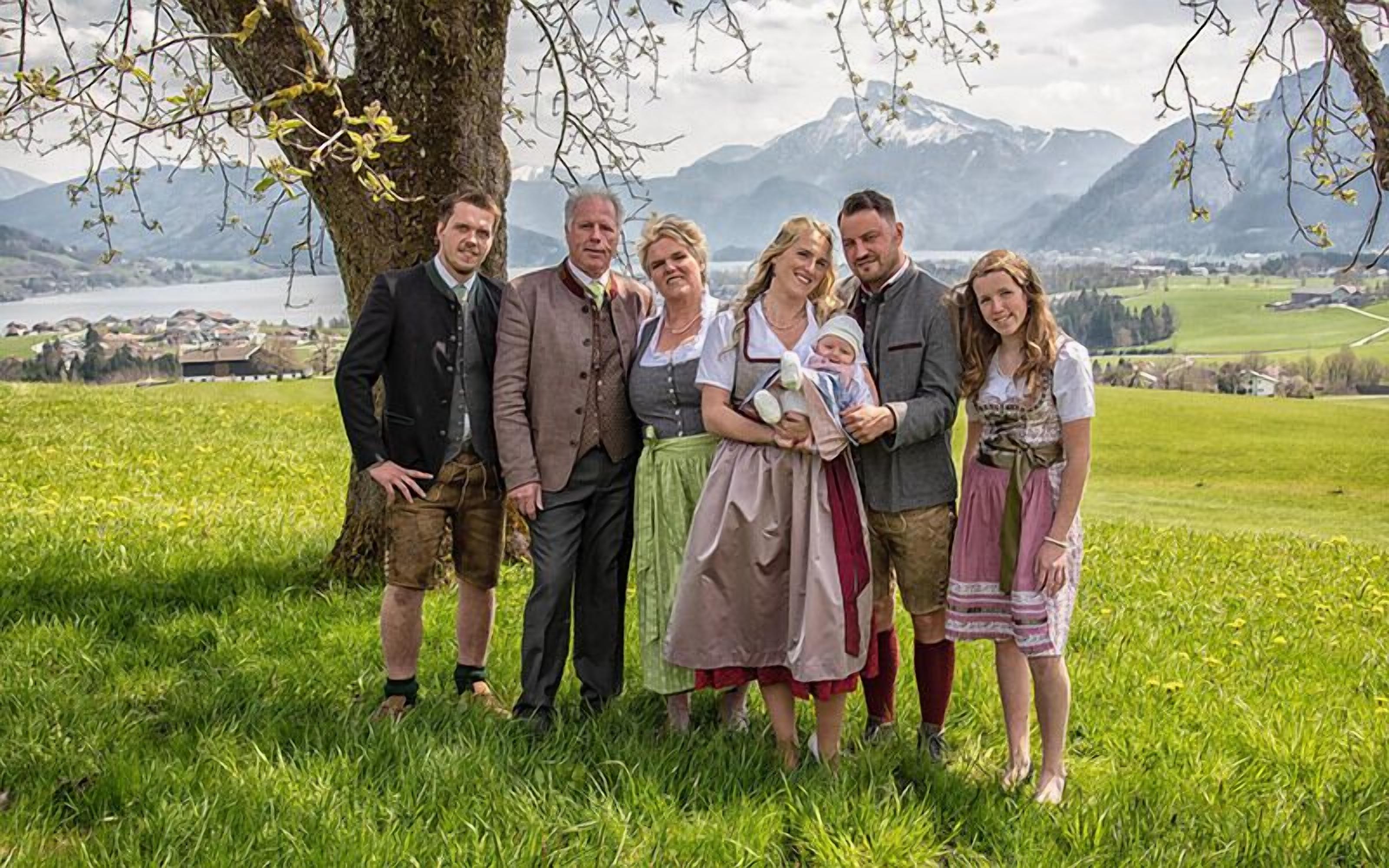 A group of people standing outdoors with a mountainous landscape in the background.