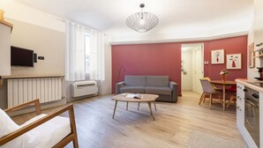 Ein modernes Wohnzimmer mit einer Couch, einem Couchtisch und einem Fernseher.