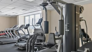 A gym with treadmills, weight machines, and a large exercise ball. - Modern Studio with Balcony in Dubai Sports City (Dubai)