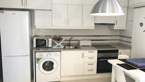 A compact kitchen with white cabinets, a microwave, a toaster, a washing machine, and a sink. - 06 Ap2116 in Denia With 2 Bedrooms and 1 Bathrooms (Denia)