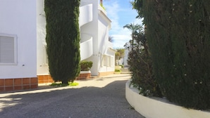A narrow street lined with white buildings, a gravel path, and neatly trimmed hedges. - 06 Ap2116 in Denia With 2 Bedrooms and 1 Bathrooms (Denia)