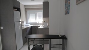 A compact kitchen with a refrigerator, sink, and a small dining table. - Ap2133 in Denia With 2 Bedrooms and 1 Bathrooms (Denia)