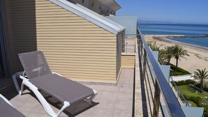 A balcony with a sun lounger and a view of the beach and ocean. - 09 At1101 in Denia With 1 Bedrooms and 2 Bathrooms (Denia)