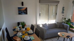 A dining area with a table set for breakfast, a sofa, and a small coffee table. - Ap3212 in Denia With 3 Bedrooms and 2 Bathrooms (Denia)