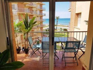 A balcony with a view of the sea, a potted plant, and two chairs. - Ap3212 in Denia With 3 Bedrooms and 2 Bathrooms (Denia)