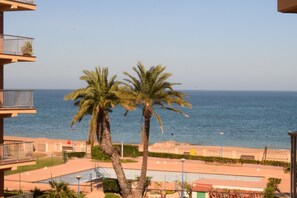 A view of a beach with palm trees and a clear sky. - Ap3212 in Denia With 3 Bedrooms and 2 Bathrooms (Denia)