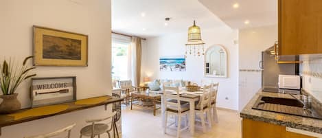 Une cuisine spacieuse avec un coin repas, un bar et une vue sur la mer.