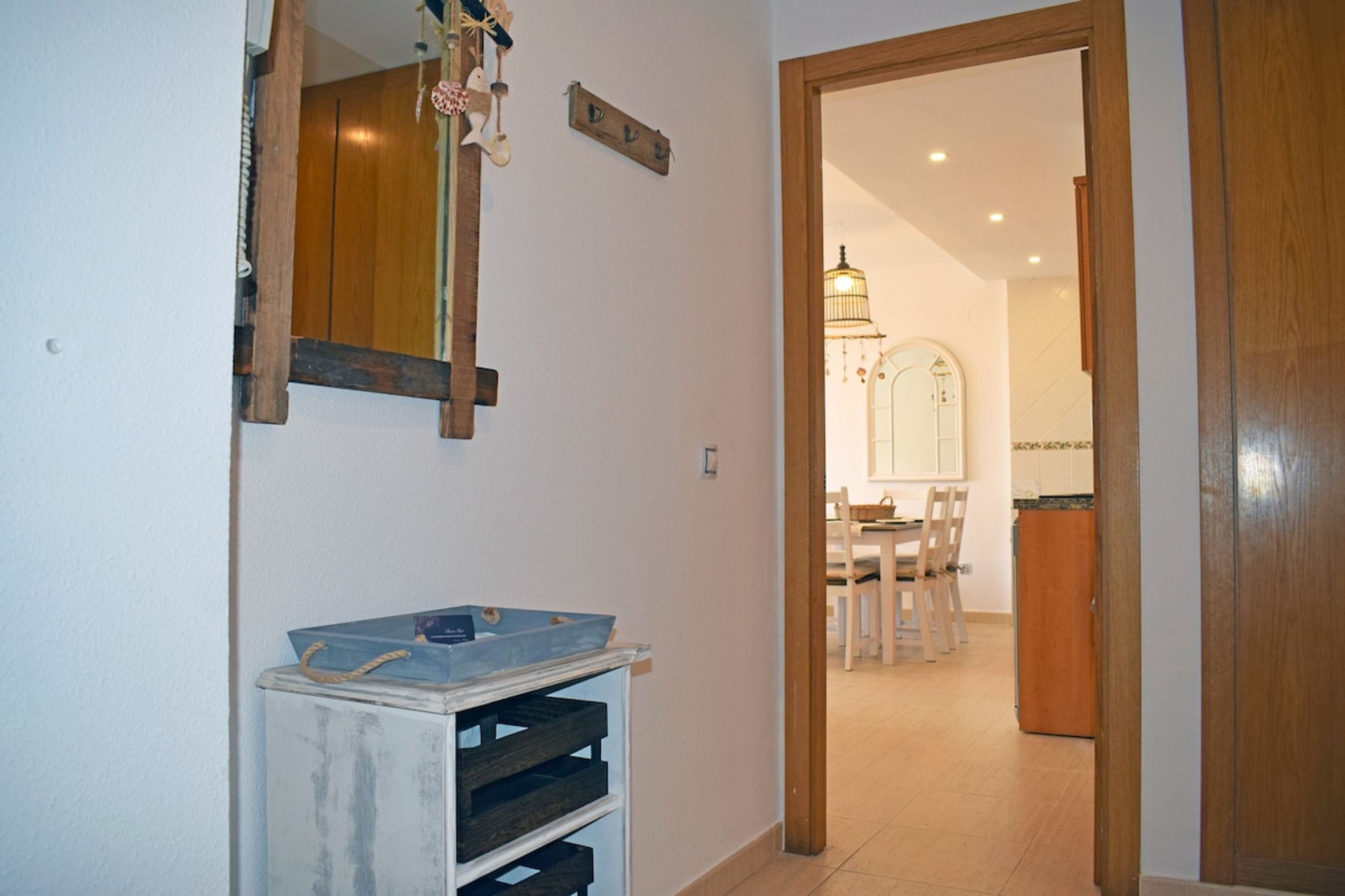Un couloir avec une porte en bois donnant sur une salle à manger.