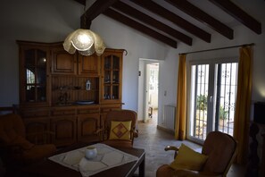 A spacious living room with wooden furniture, a large cabinet, and a view through a glass door to the outside. - Ch3215 in Denia With 3 Bedrooms and 2 Bathrooms (Denia)