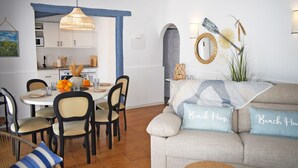 A dining area with a table set for four, surrounded by chairs. There is a kitchen visible in the background with cabinets and a microwave. - Ch3400 in Denia With 3 Bedrooms and 2 Bathrooms (Denia)