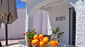 A table with a bowl of oranges, a glass of orange juice, and a potted plant. - Ch3400 in Denia With 3 Bedrooms and 2 Bathrooms (Denia)