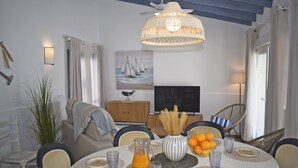 A dining area with a round table, chairs, a TV, and a ceiling fan. - Ch3400 in Denia With 3 Bedrooms and 2 Bathrooms (Denia)