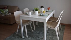 A dining area with a white table, four chairs, and a patterned rug. - Ap625 in Oliva With 2 Bedrooms and 2 Bathrooms (Oliva)