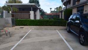 Ein Parkplatz mit einem Auto in einem dafür vorgesehenen Stellplatz.