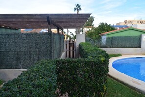 A swimming pool surrounded by a wooden pergola and a high fence. - Ap2213 in Denia With 2 Bedrooms and 2 Bathrooms (Denia)