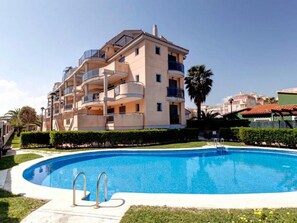 A multi-story residential building with balconies, a swimming pool, and a well-maintained lawn. - Ap2213 in Denia With 2 Bedrooms and 2 Bathrooms (Denia)