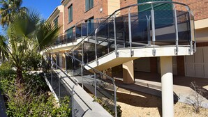 A glass bridge connecting two buildings with a brick facade and green shutters. - Dup3291 in Oliva With 3 Bedrooms and 2 Bathrooms (Oliva)