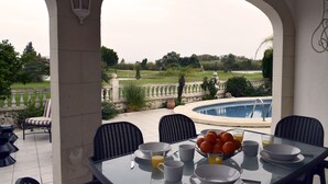 A dining area with a view of a swimming pool and garden. - Ch1100 in Oliva With 2 Bedrooms and 2 Bathrooms (Oliva)