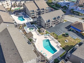 An aerial view of a residential building with two swimming pools, a parking area, and a FedEx delivery truck. - Oceanview Shore Dr  2BR Condo (Myrtle Beach)