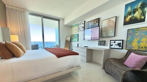 A modern hotel room with a large bed, a desk, and a view of the sea. - 37th Floor OCEAN VIEW Retreat - 2BR Hollywood (Hollywood)