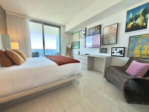 Ein modernes Hotelzimmer mit einem großen Bett, einem Schreibtisch und Blick auf das Meer.