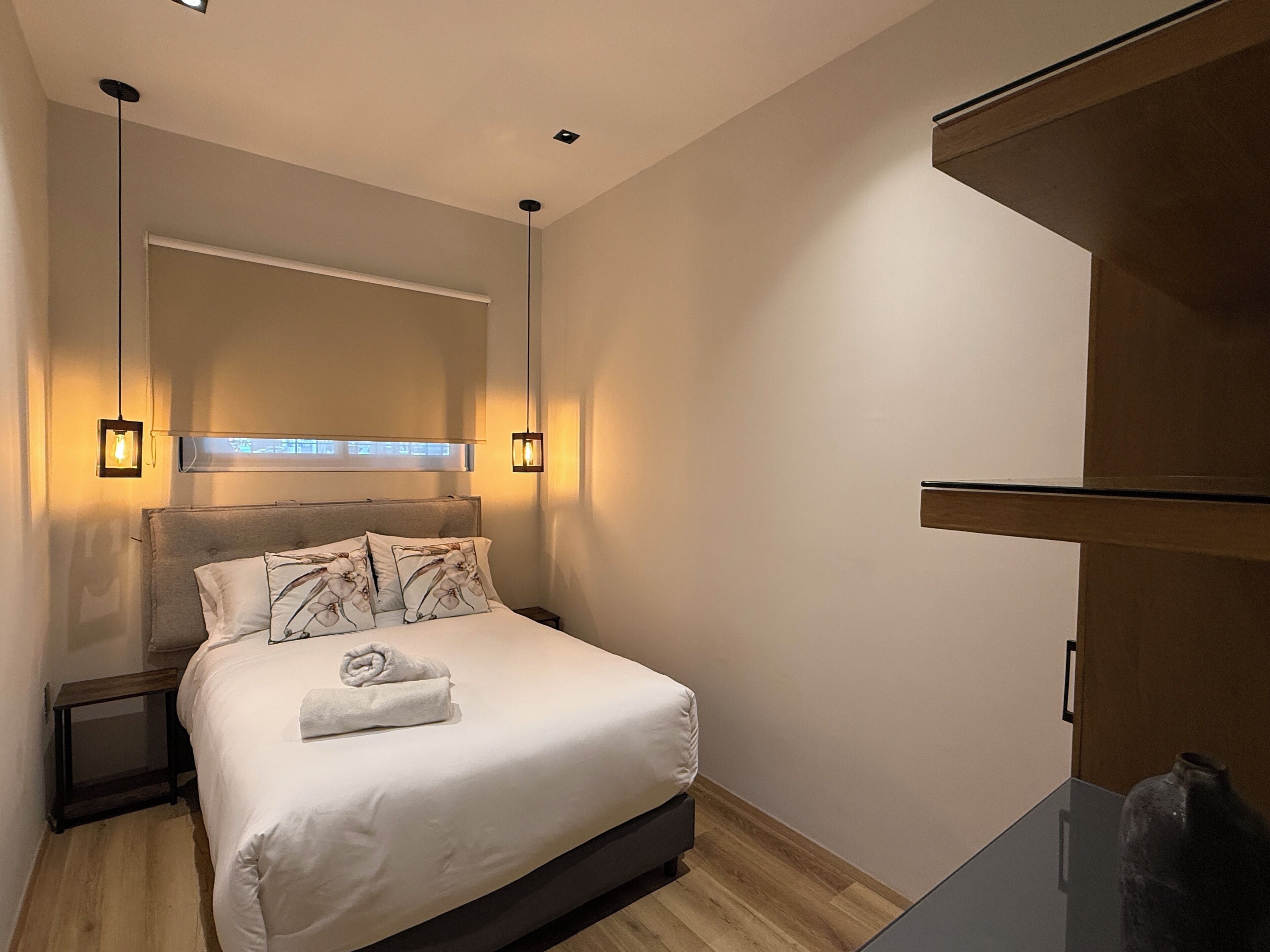 Ein modernes Schlafzimmer mit Bett, Nachttischen und einem Spiegel.