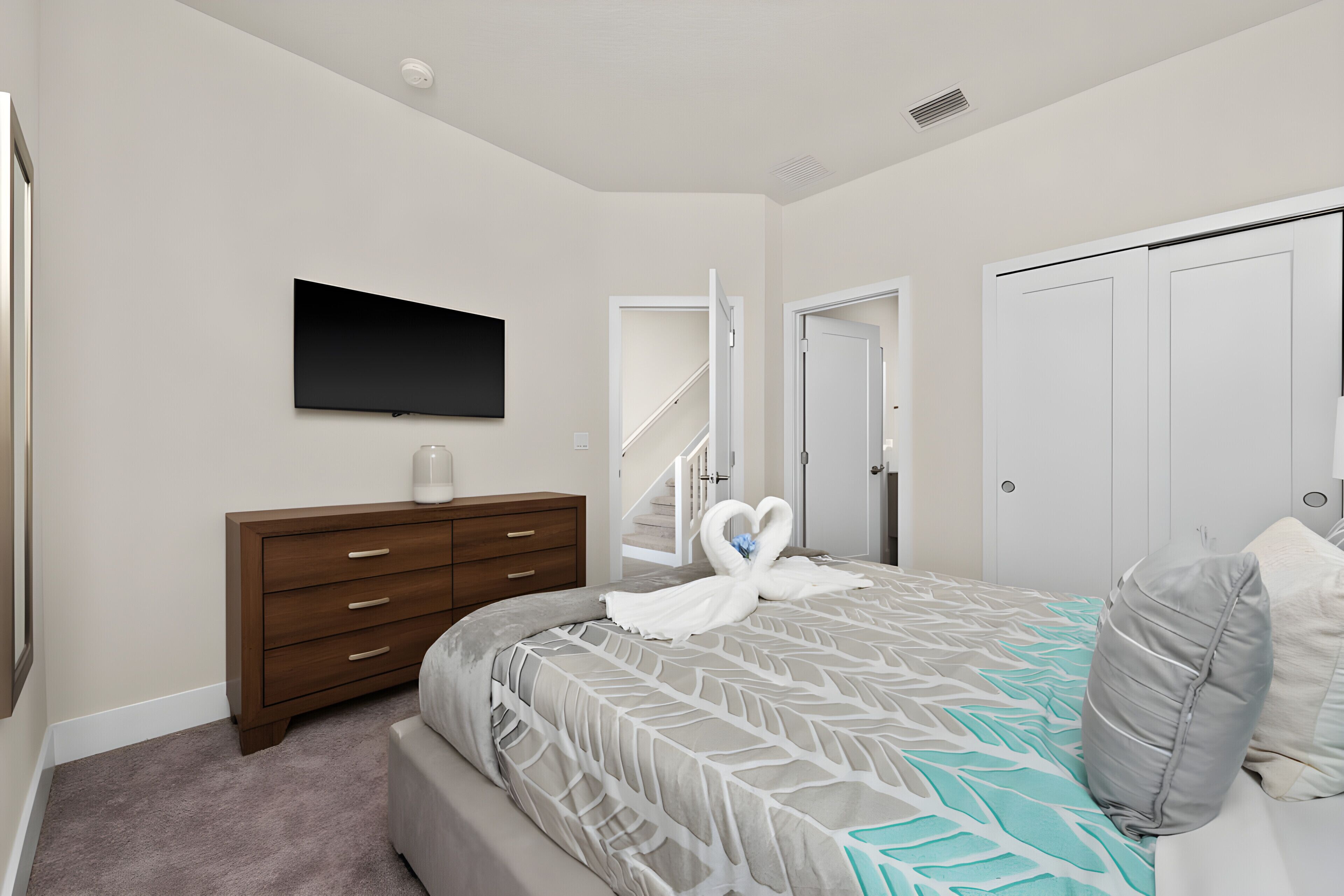 A bedroom with a bed, a dresser, a TV, a staircase, and a closet.