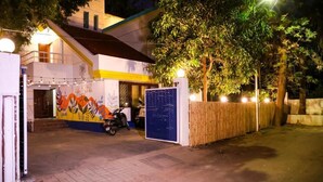 A building with a mural, a parked scooter, and a gated entrance. - THE PUNE STORY HOSTEL (Pune)
