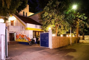 A building with a mural, a parked scooter, and a gated entrance. - THE PUNE STORY HOSTEL (Pune)