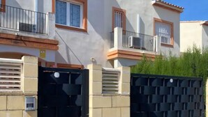 Een woongebouw met een hekpoort, een balkon en een raam met uitzicht.