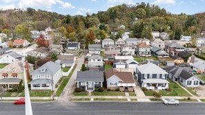 A residential area with houses, a street, and a hilly background.