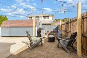 A backyard with a barbecue area, outdoor seating, and a wooden fence.