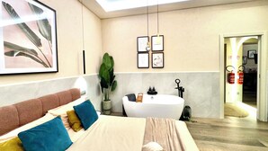 Une chambre d’hôtel moderne avec un grand lit, une baignoire et une grande fenêtre.
