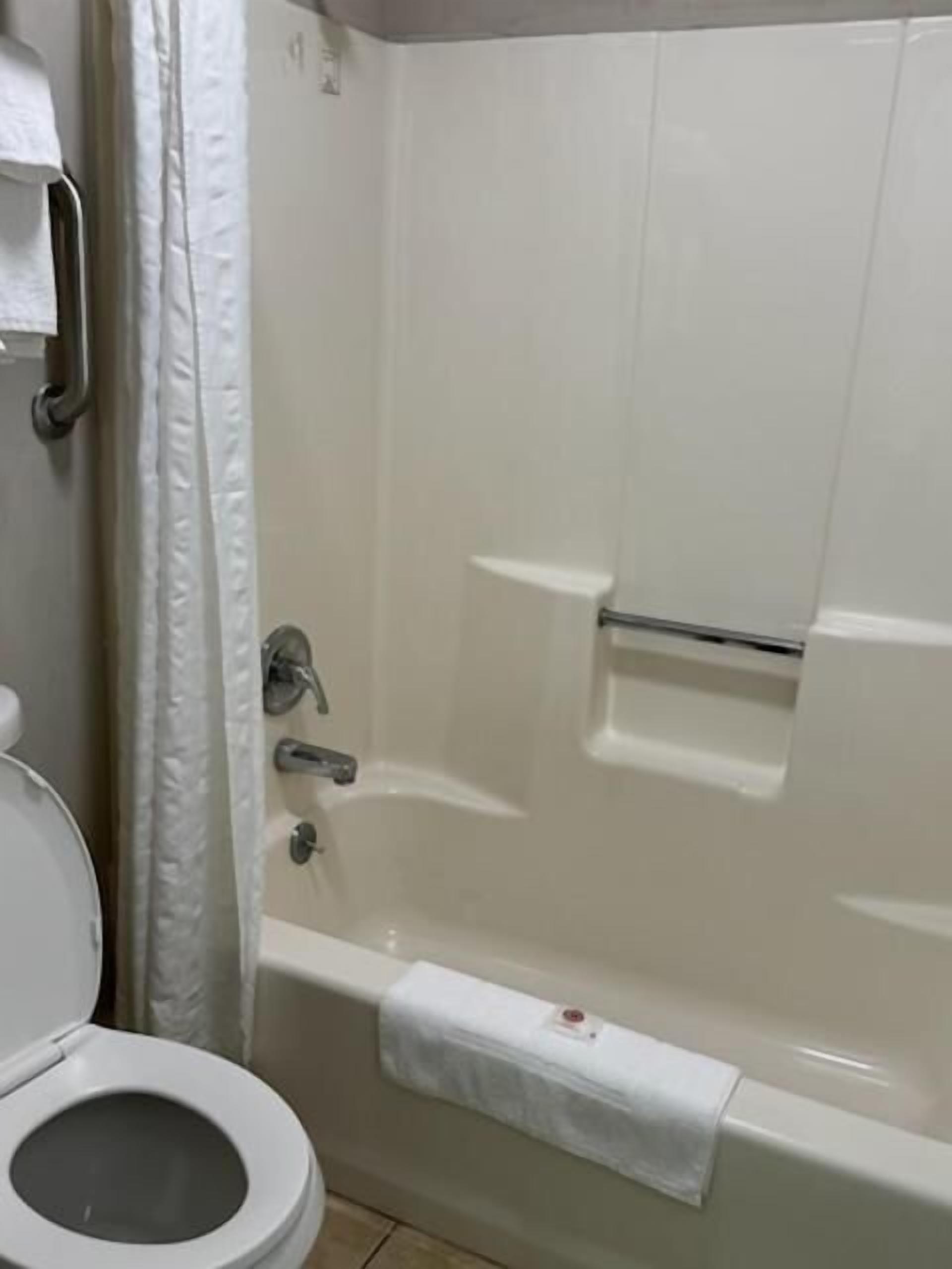 Ein Badezimmer mit Toilette, Dusche und Badewanne.