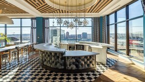 Una cocina moderna con una isla central, ventanas amplias y vistas a la ciudad.