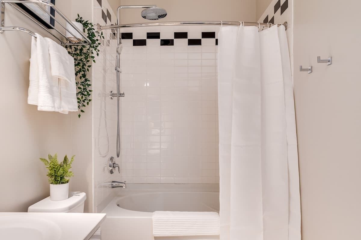 A modern bathroom with a shower, toilet, and sink.
