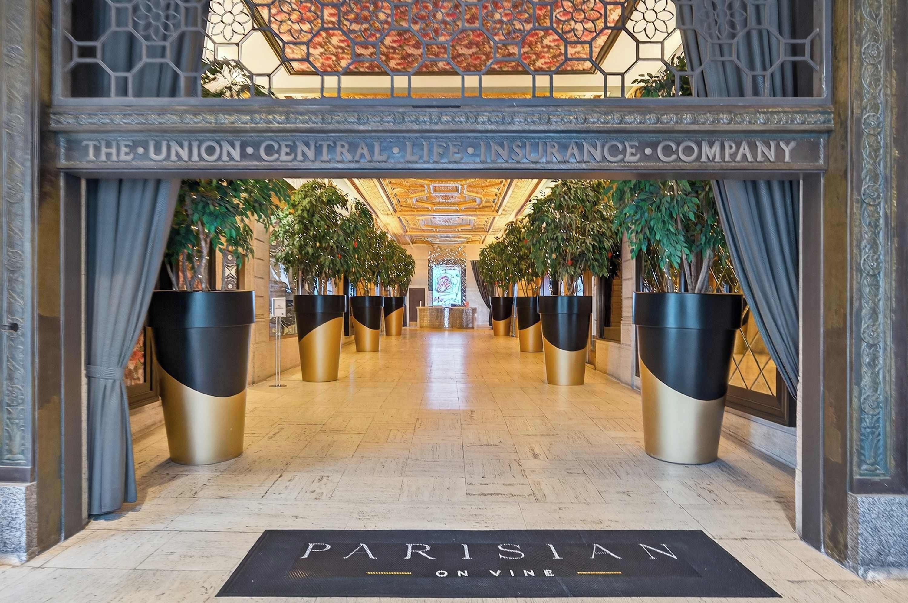 A grand entrance with a sign reading "The Union Central Life Insurance Company" and a sign at the end of the corridor that says "Parisian on Vine."