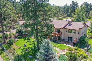 A two-story house with a covered patio and a fenced yard. - 120 Winding Meadow (Monument)
