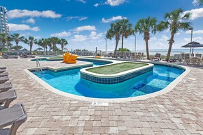 A swimming pool with a tiled edge, lounge chairs, and palm trees. - Atlantica 656 (Myrtle Beach)