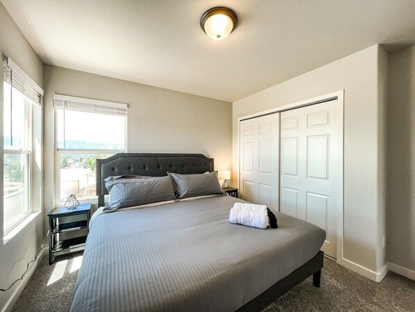 A bedroom with a large bed, a nightstand, a dresser, and a closet. - 15524 Candle Creek (Monument)