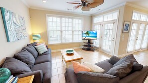 A living room with a sofa set, a coffee table, a TV, and a painting on the wall. - Caribbean Cove 504 (Myrtle Beach)