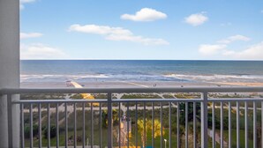 Uma varanda com vista para a praia e o oceano.
